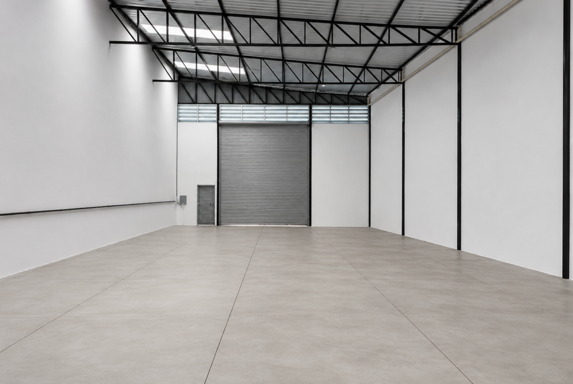 Área de armazenamento de 380 m² com porta automática ao fundo e estrutura metálica aparente