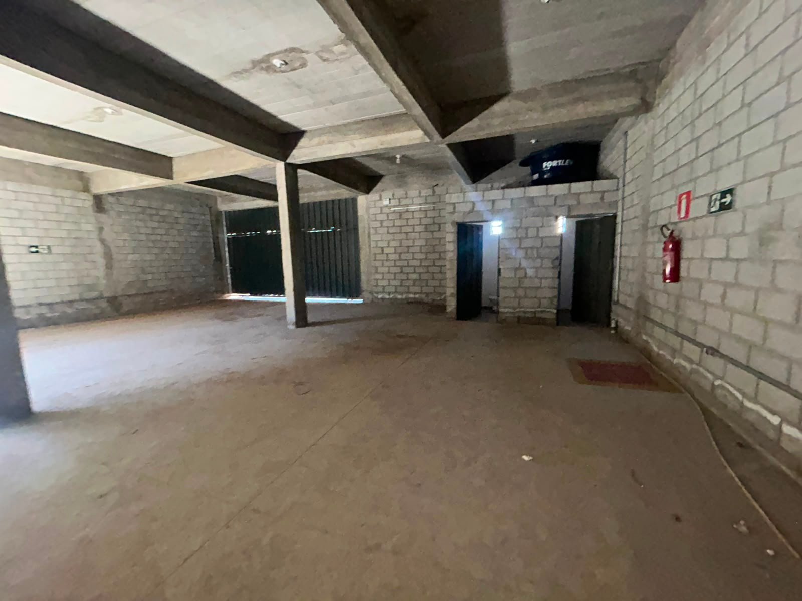 Subsolo do galpão em Petrolândia, Betim, com vigas de concreto aparentes e piso liso