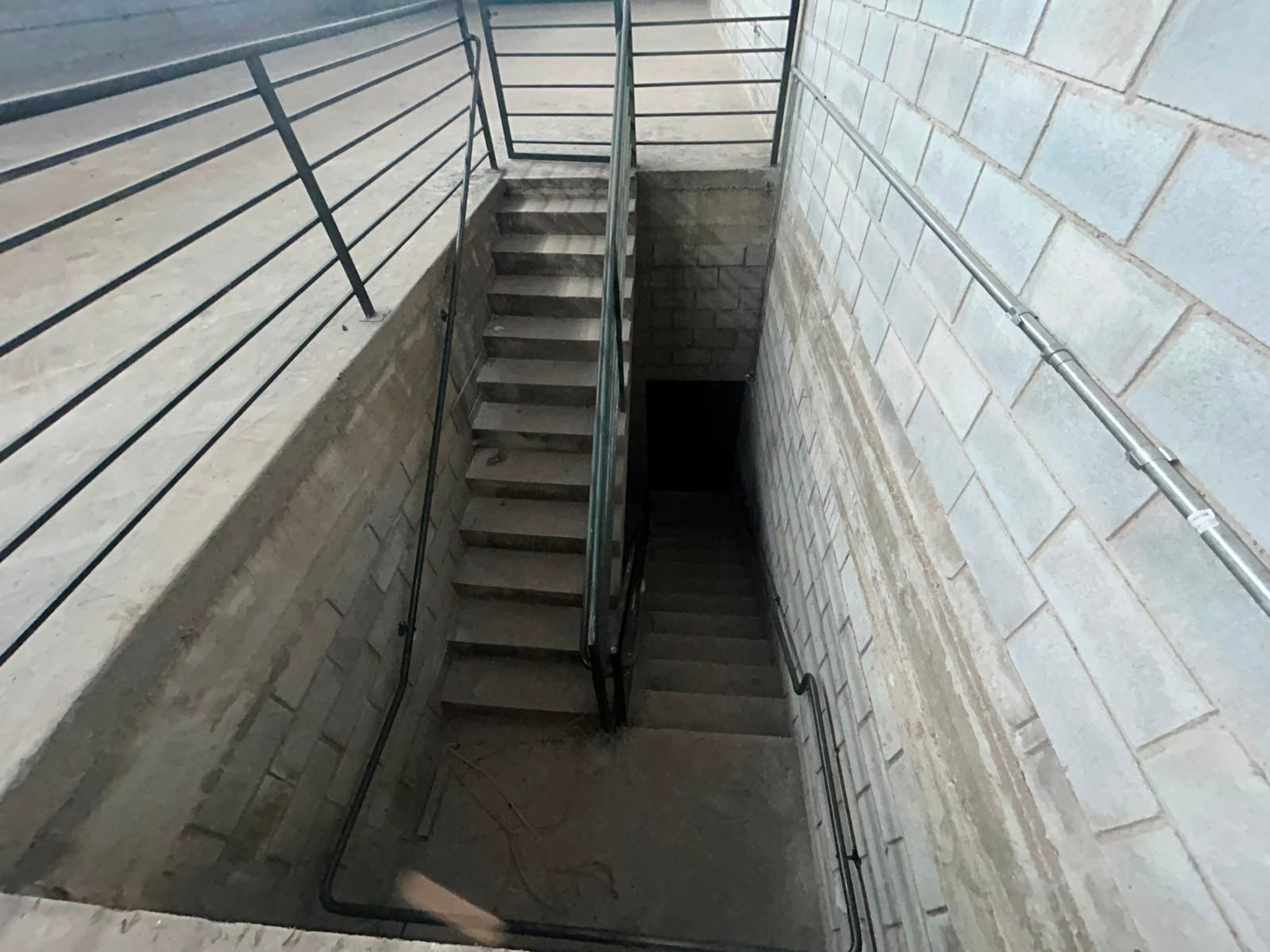 Escada de acesso ao subsolo do galpão em Betim, com guarda-corpo metálico