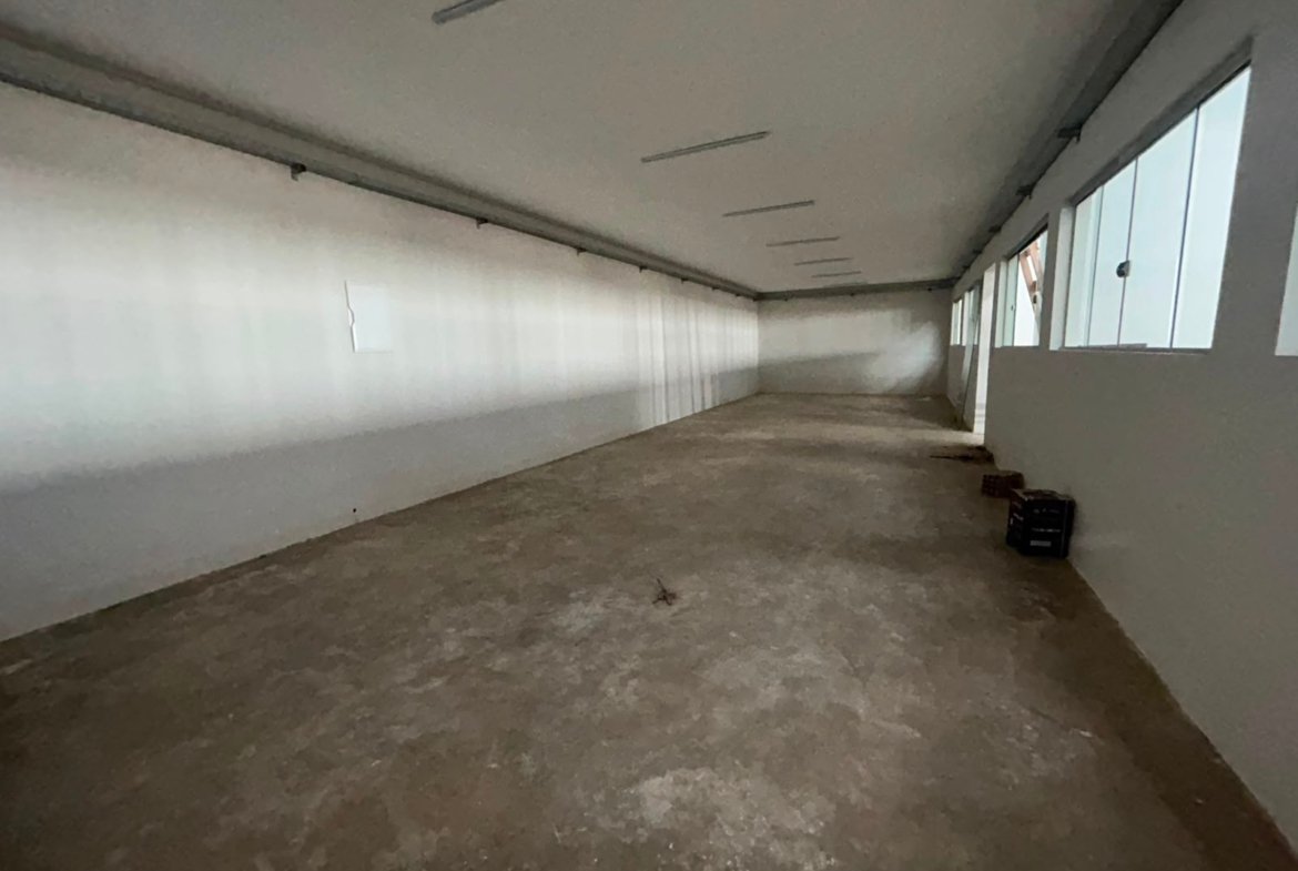 Sala ampla do escritório, com iluminação natural por janelas altas