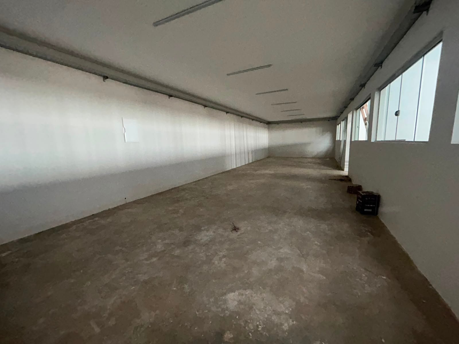 Sala ampla do escritório, com iluminação natural por janelas altas