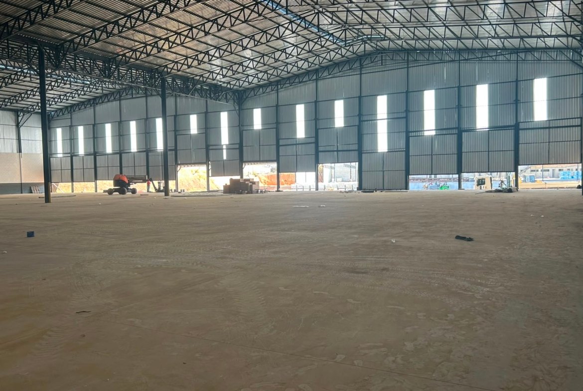 Salão de armazenagem com iluminação natural nas laterais e piso industrial