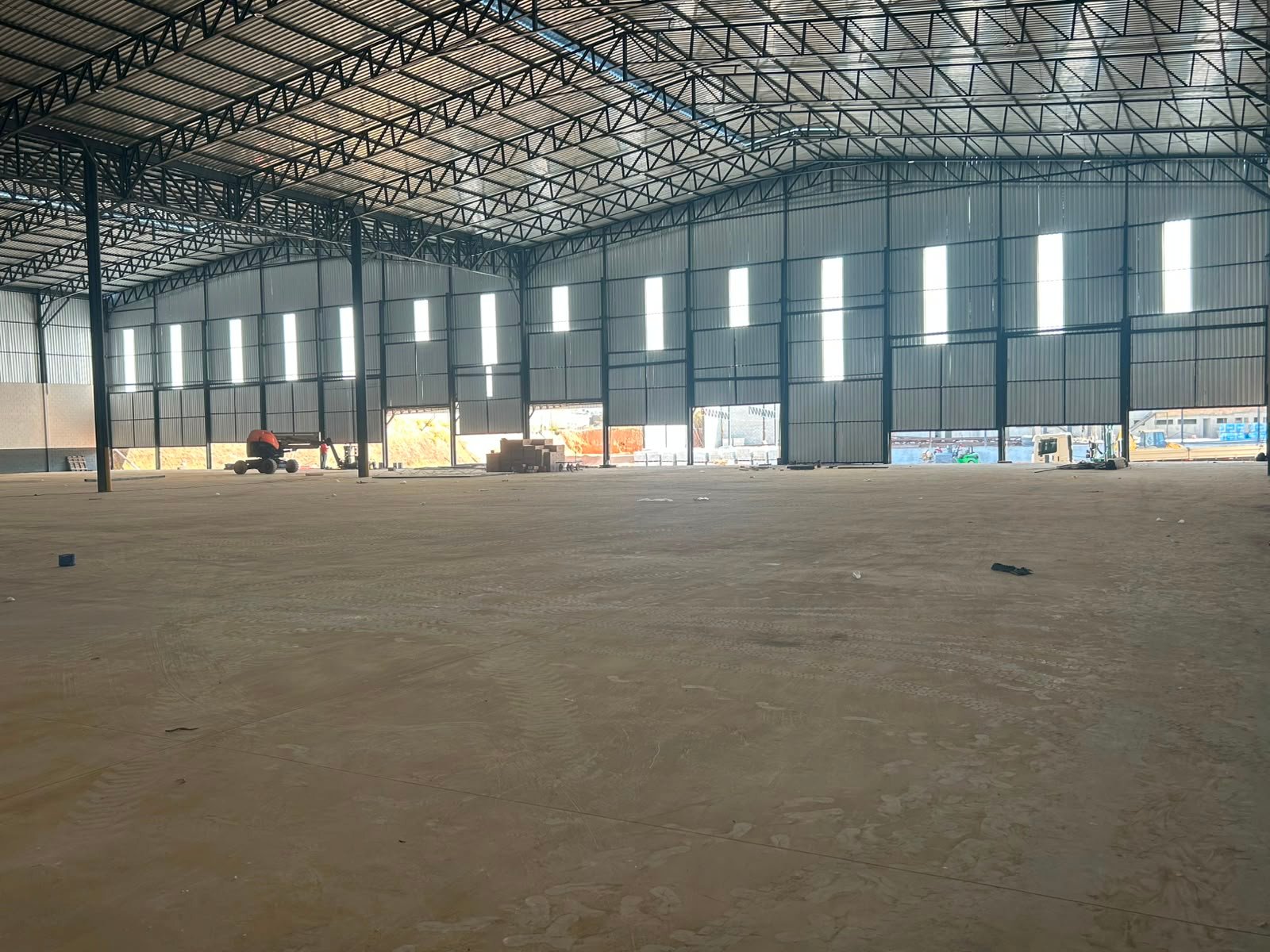 Salão de armazenagem com iluminação natural nas laterais e piso industrial