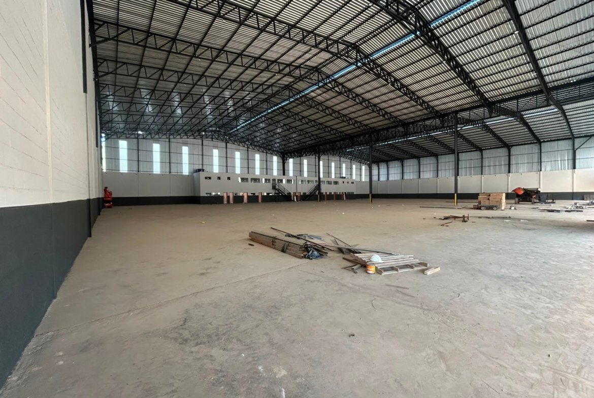 Amplo salão do galpão em Contagem, com piso industrial polido e telhado metálico