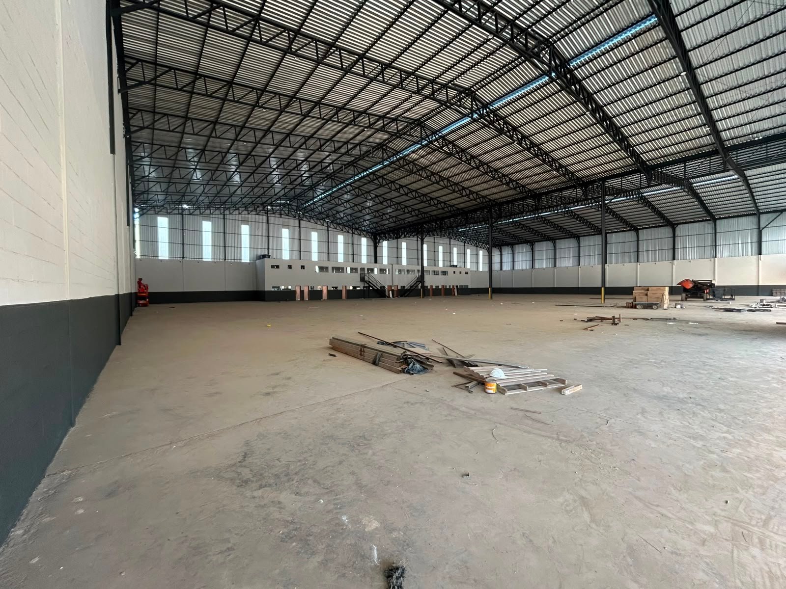 Amplo salão do galpão em Contagem, com piso industrial polido e telhado metálico