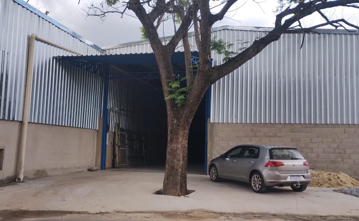 Fachada do galpão de 420 m² no bairro Arquipélago Verde, em Betim/MG, com portão de acesso azul e fechamento em telha metálica
