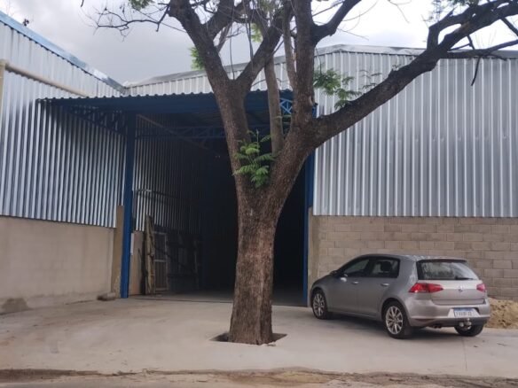Fachada do galpão de 420 m² no bairro Arquipélago Verde, em Betim/MG, com portão de acesso azul e fechamento em telha metálica