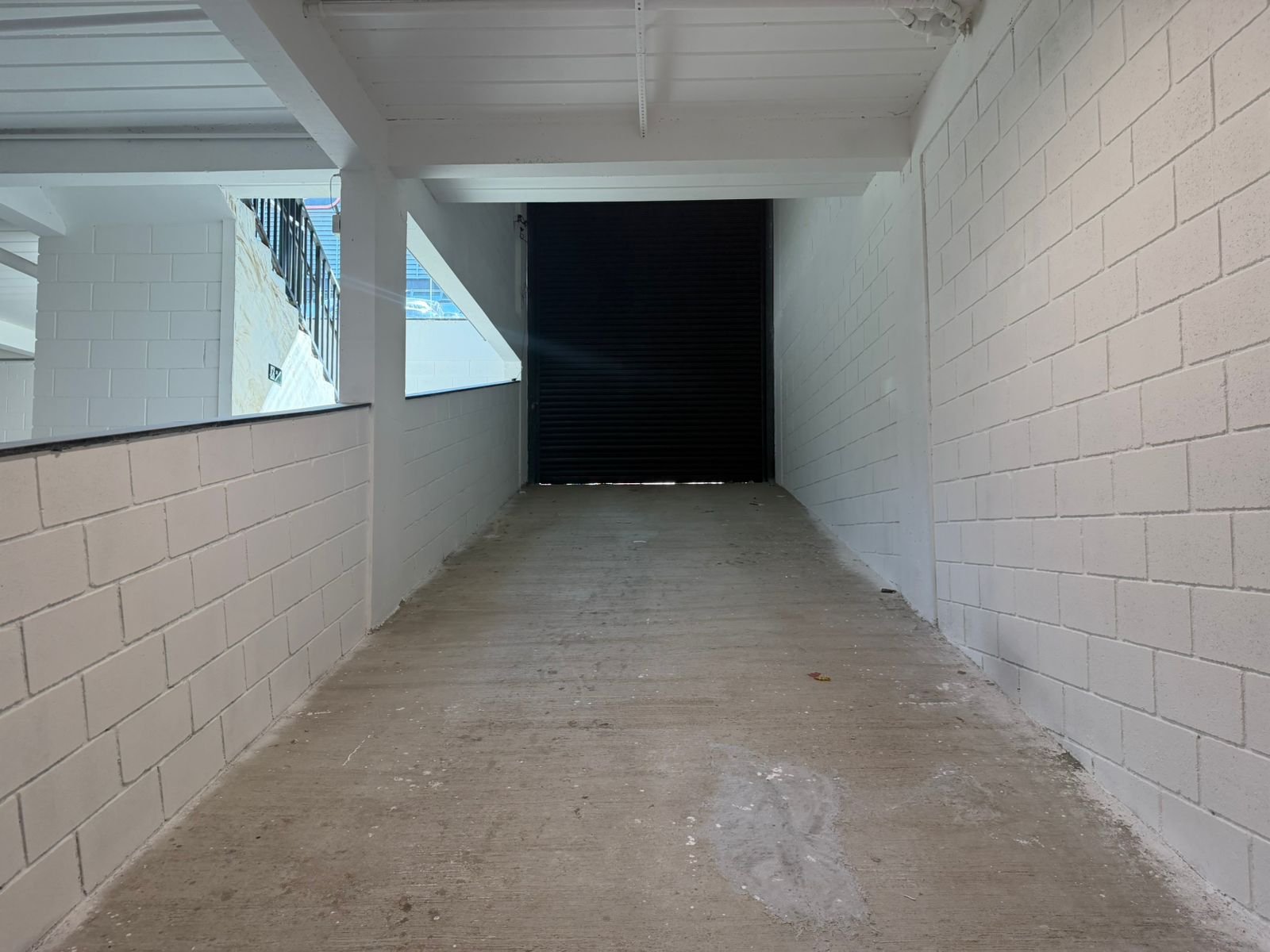 Rampa de acesso ao subsolo do galpão no Riacho das Pedras, com portão de 3,50 x 5,00 metros para veículos